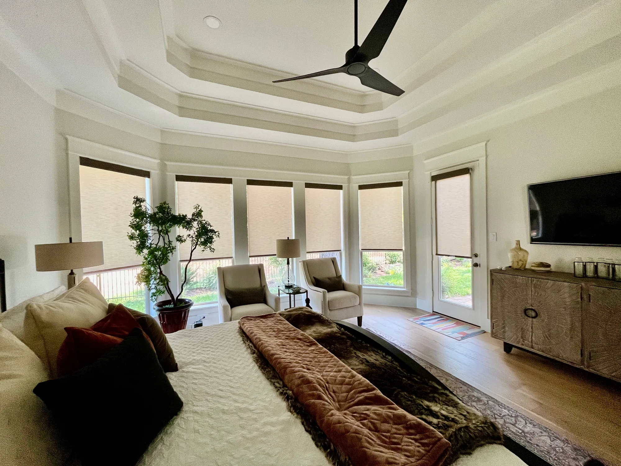Curved living room with custom roller shades installed by Love Is Blinds