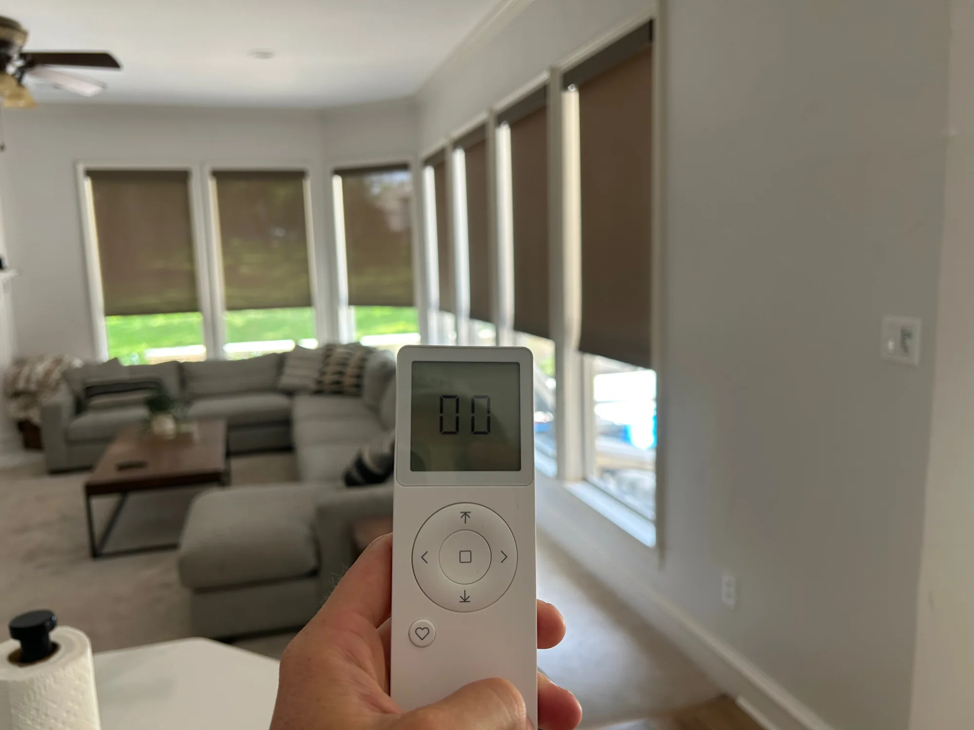 Remote control operating motorized window shades installed by Love Is Blinds