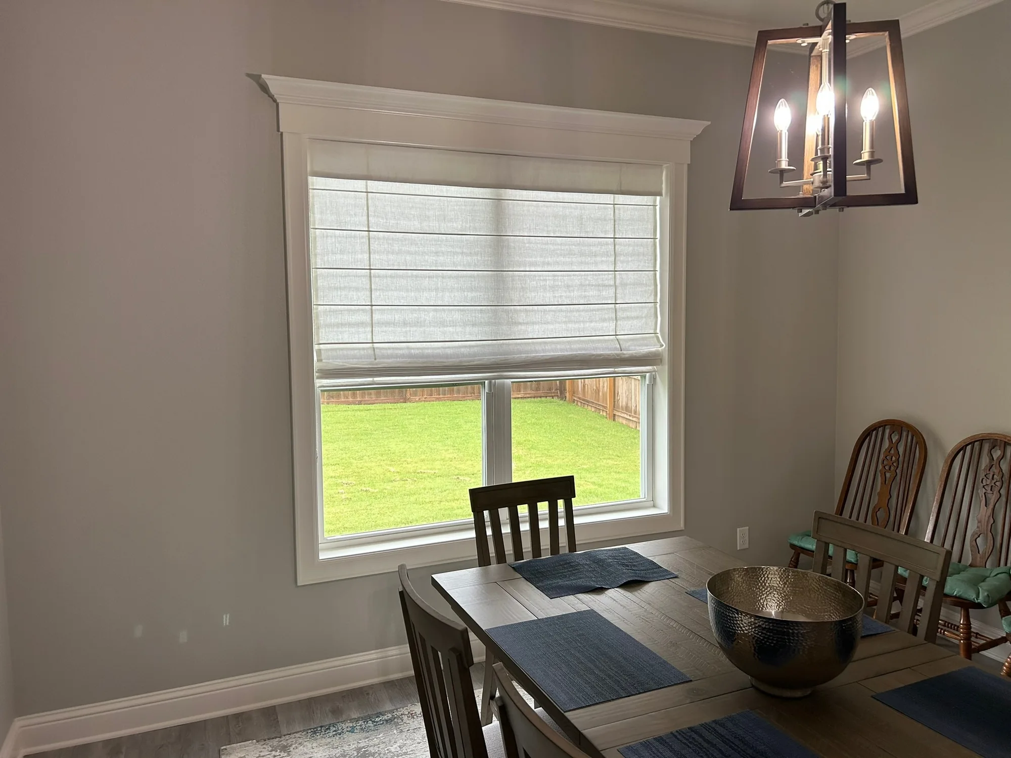 Roman shade over a dining table installed by Love Is Blinds